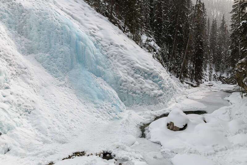 From Banff: Johnston Canyon Guided Icewalk - Lower Falls: Frozen Water Mid-Stream and a Tunnel Close-Up